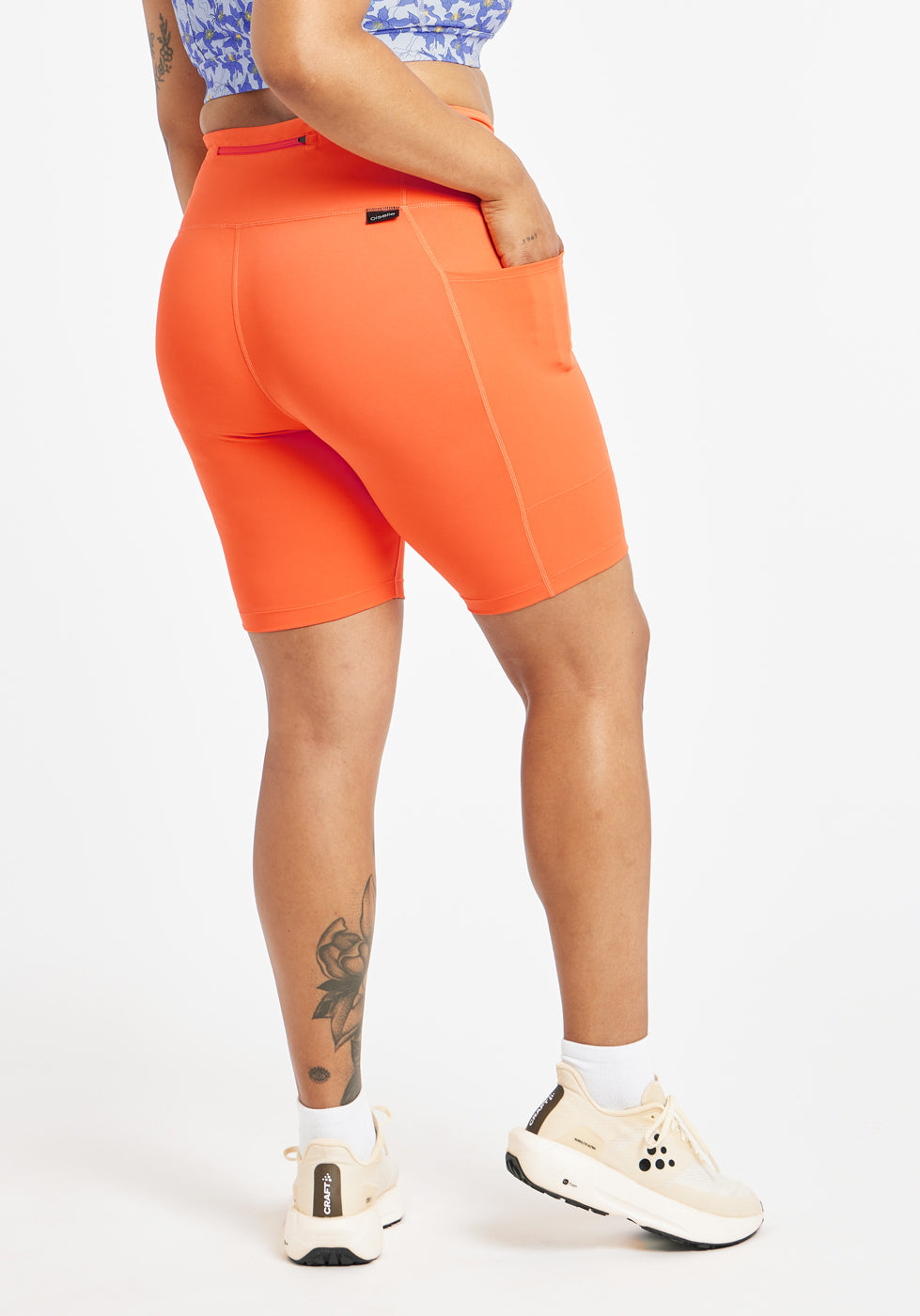 Woman wearing orange compression shorts in size 12, back view