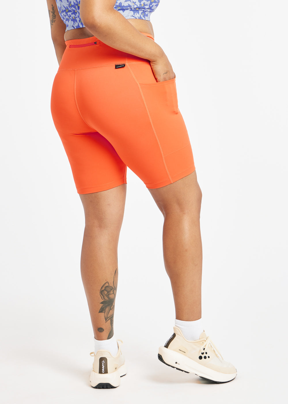 Woman wearing orange compression shorts in size 12, back view
