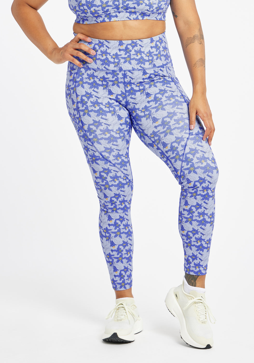 Woman wearing blue with blue flower print running tights in size 12, front view