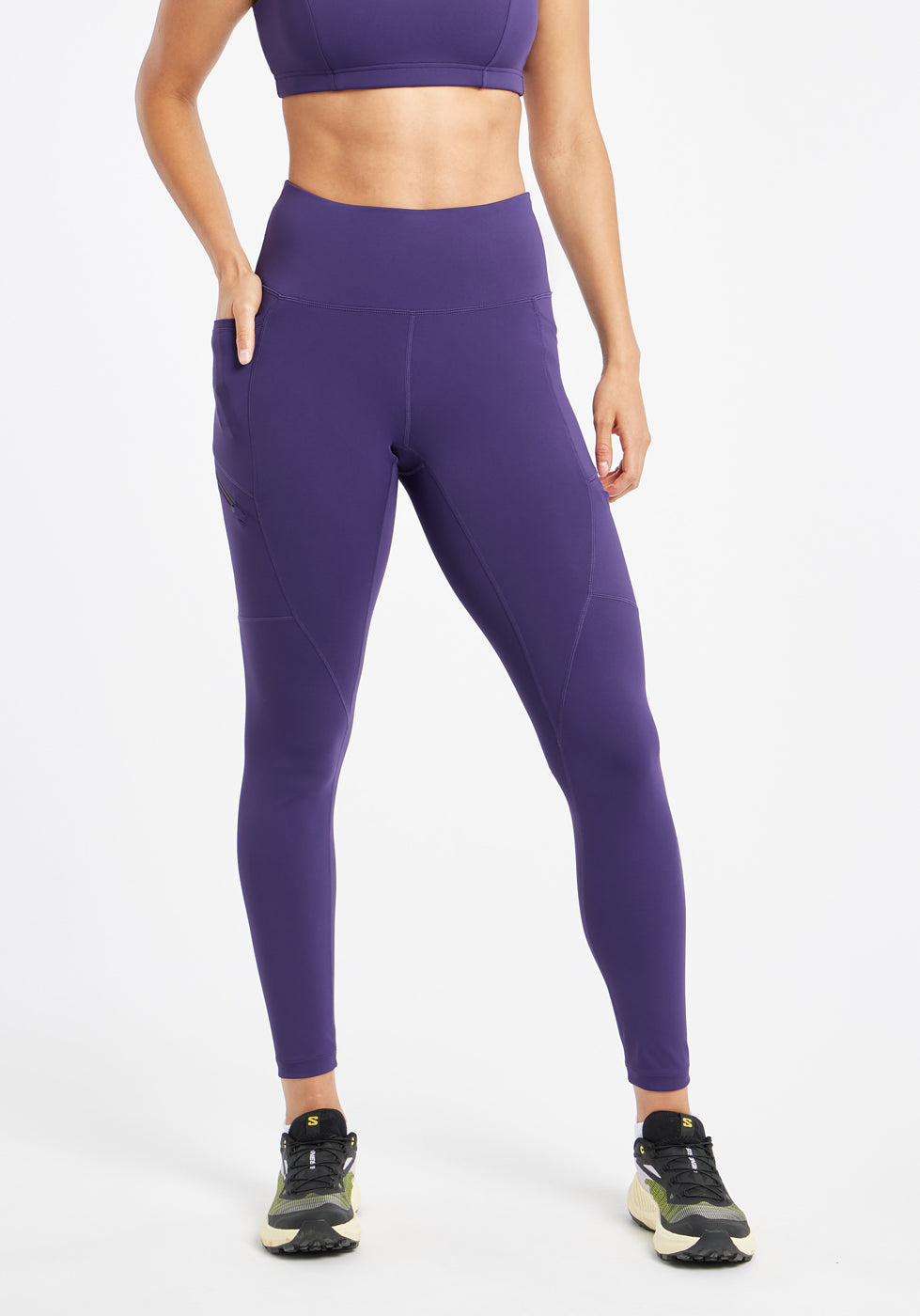 Woman wearing purple running tights in size 6, front view