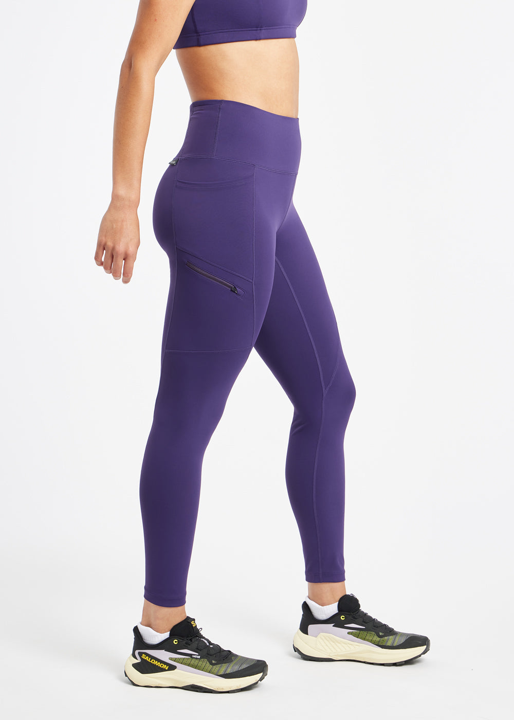 Woman wearing purple running tights in size 6, side view
