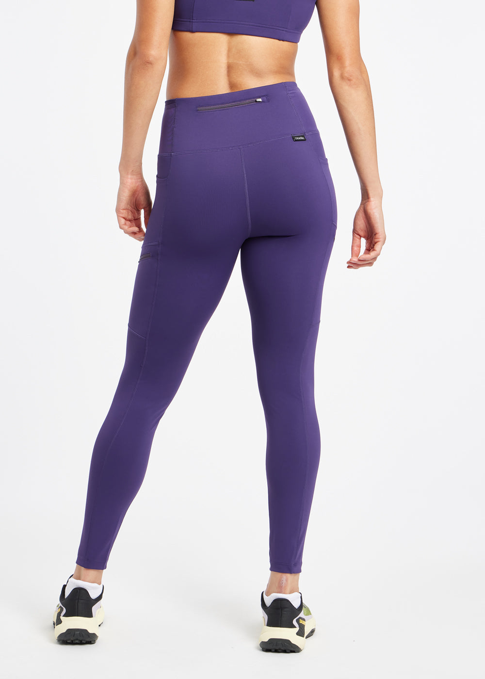 Woman wearing purple running tights in size 6, back view