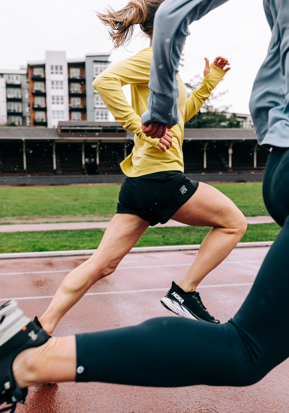 Women running on a track in Roga 4" Running Shorts in Black