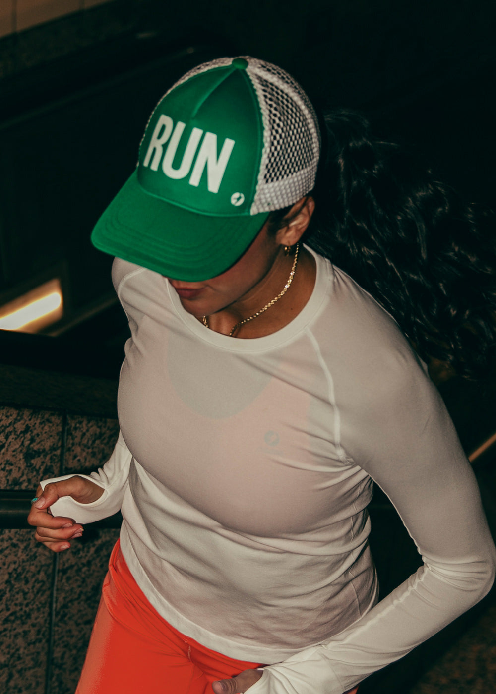 Runner Trucker Hat in Green with RUN on front panel, running at night view