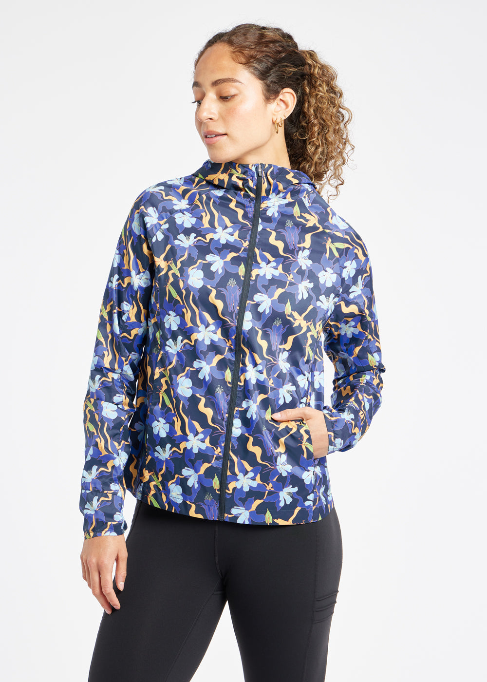 Whirlwind Running Jacket in Ink Blue Aquila Bloom Floral Print, front view with hand in pocket
