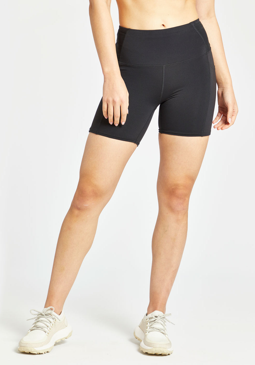 Woman wearing black compression shorts in size 4, alternate front view