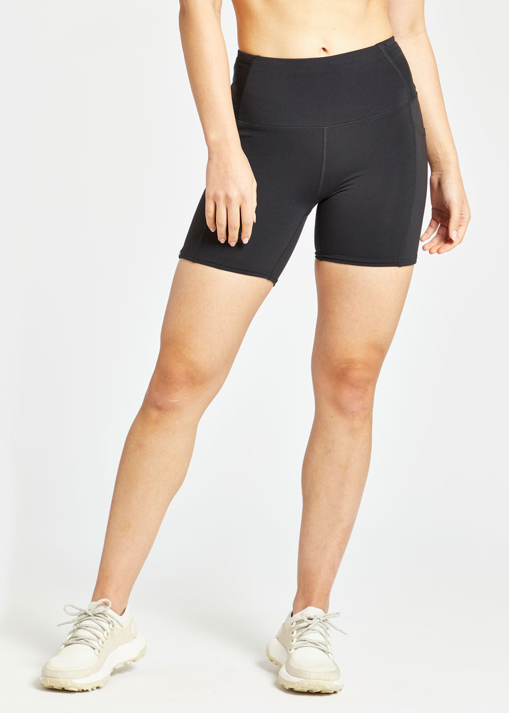 Woman wearing black compression shorts in size 4, alternate front view