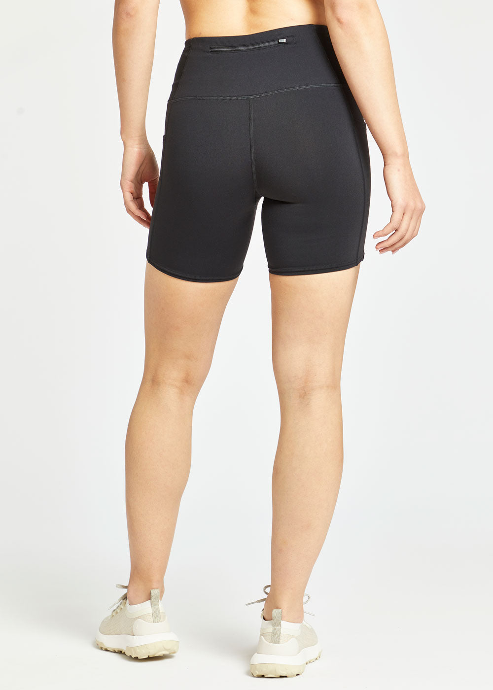 Woman wearing black compression shorts in size 4, back view