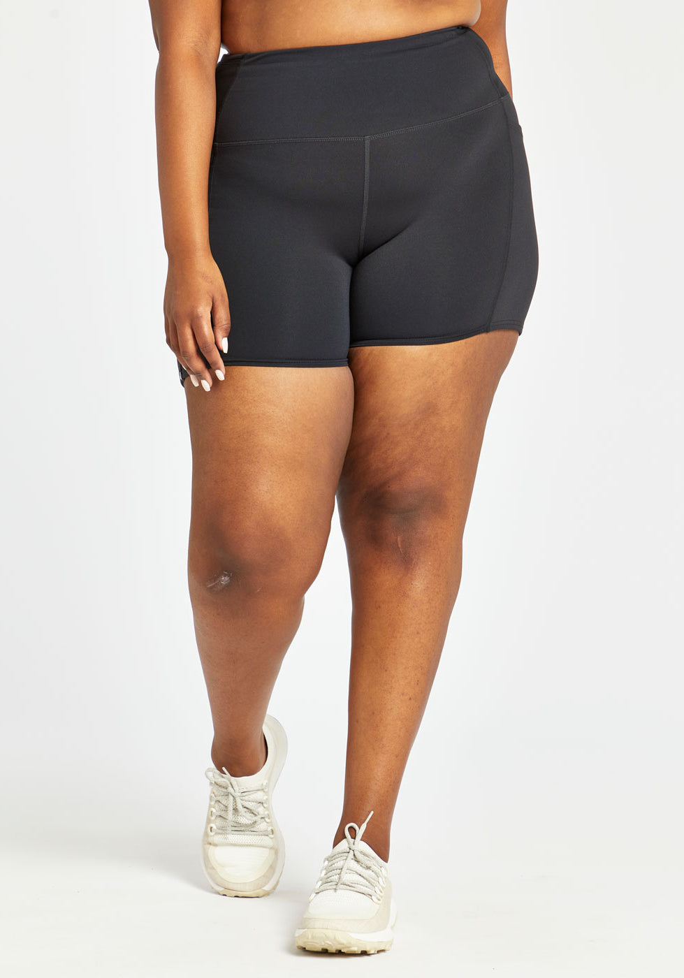 Woman wearing black compression shorts in size 16/18, front view