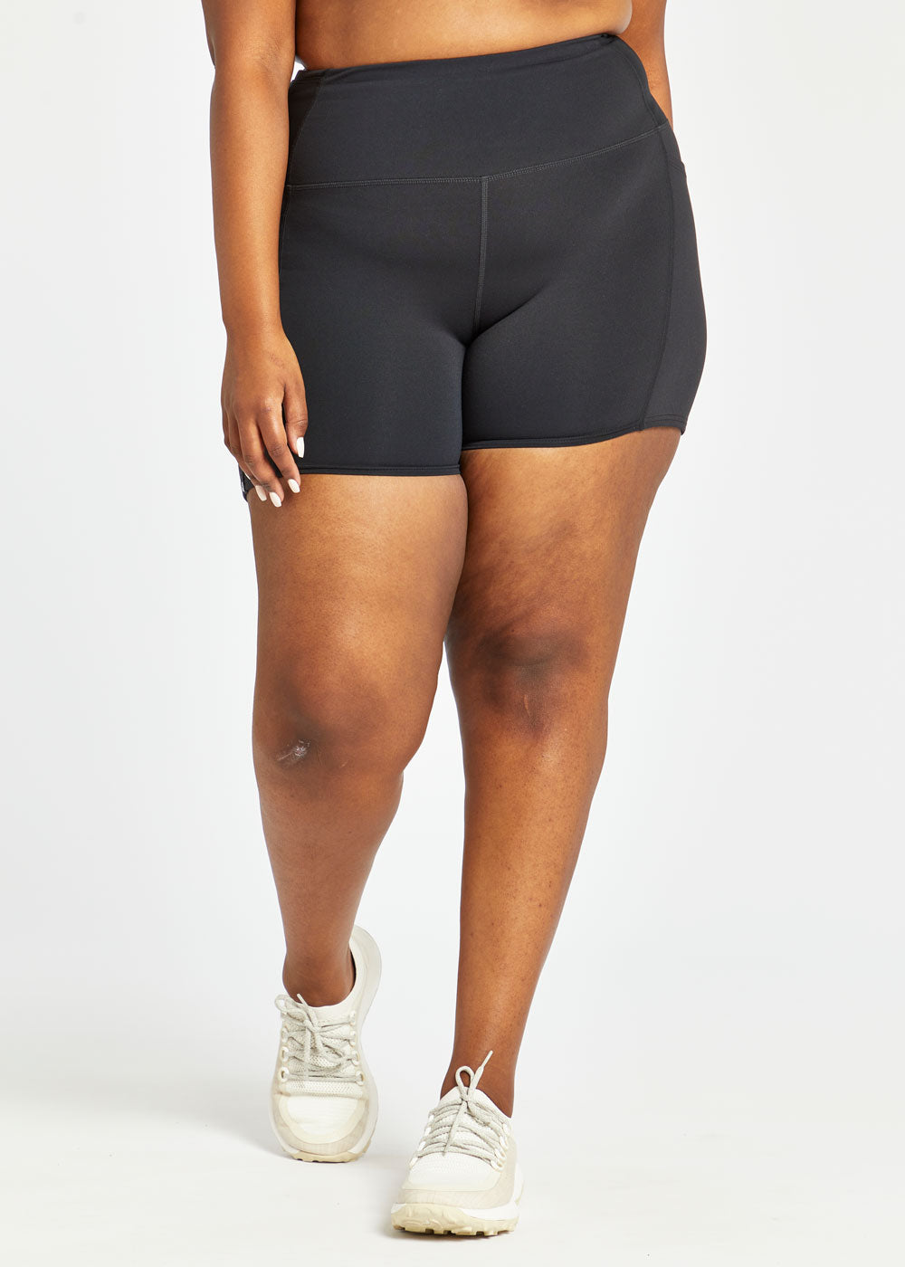 Woman wearing black compression shorts in size 16/18, front view