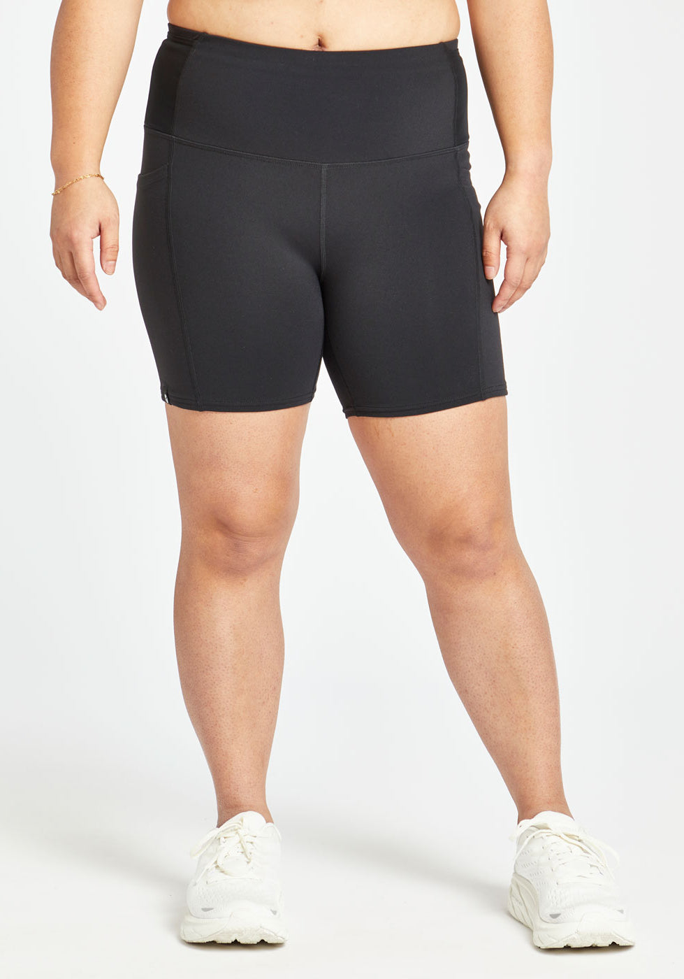 Woman wearing black compression shorts in size 8, front view