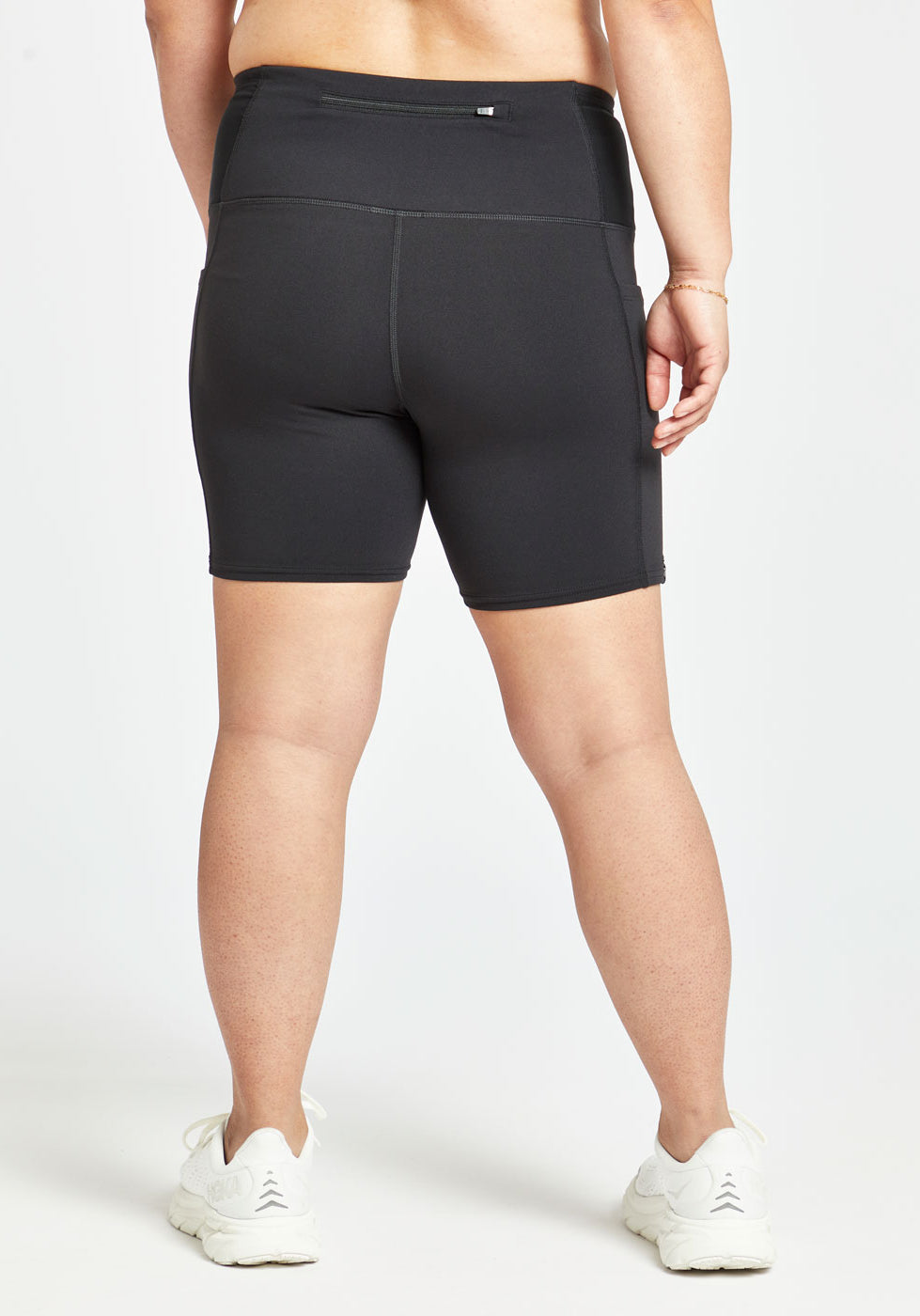 Woman wearing black compression shorts in size 8, back view