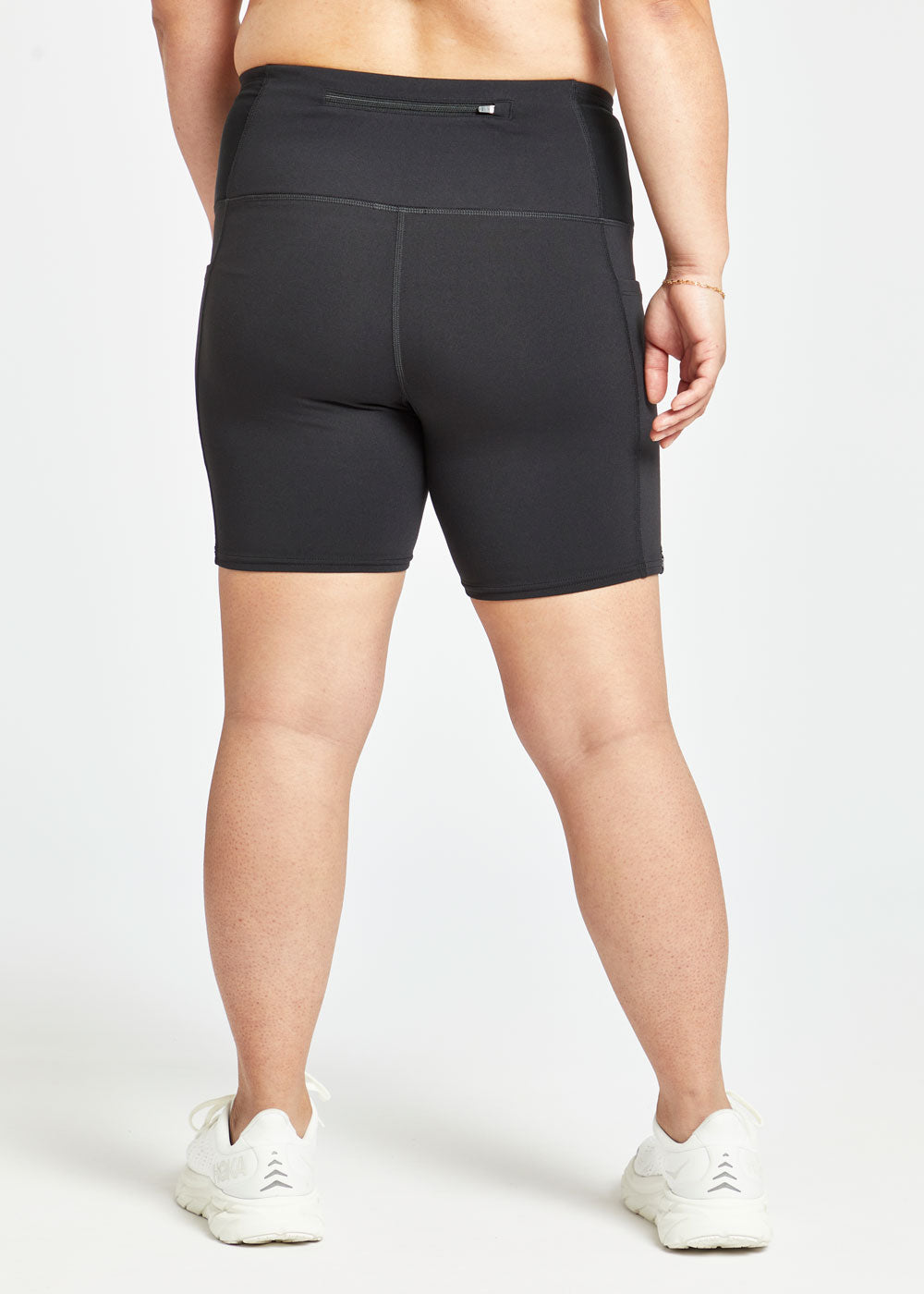 Woman wearing black compression shorts in size 8, back view