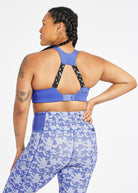 Woman wearing blue band and cup sports bra, back view