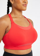 Woman wearing red orange band and cup sports bra, close up view of mesh panels