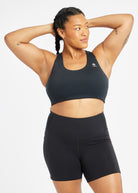 Woman wearing black and white paneled sports bra, front view