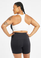 Woman wearing black and white paneled sports bra, back view