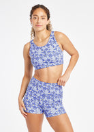Woman wearing blue with blue floral print sports bra in size 6, front view