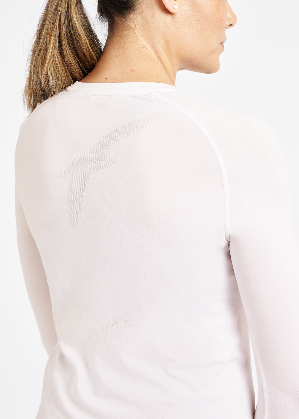 Woman wearing a white running long sleeve, close up of bird details on shirt
