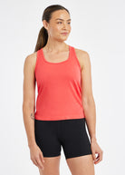 Woman wearing a red orange running tank top and black compression shorts, front view