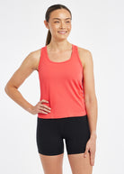 Woman wearing a red orange running tank top and black compression shorts, alternate front view
