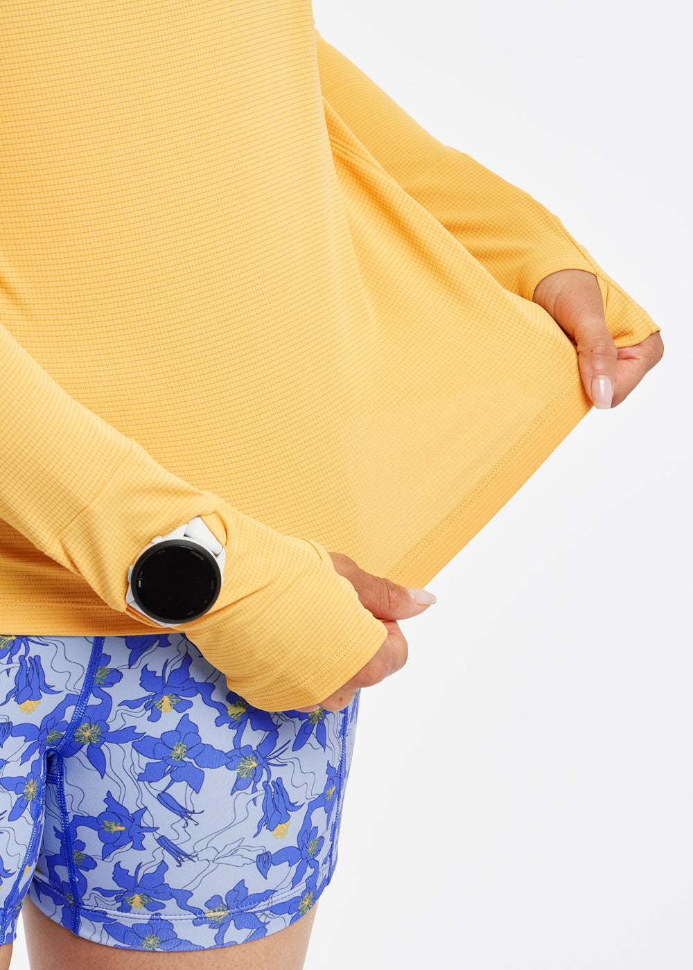 Flyout Chill UPF Lightweight Running Hoodie in Dawn Patrol light orange, detail view of fabric and watch window on sleeve