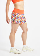 Roga 6" Running Shorts in colorful checkered print with orange waistband, side view