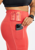 Woman wearing red orange compression tights, close up of side pockets