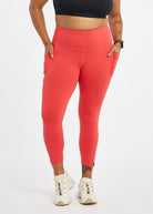 Woman wearing red orange compression tights in size 12, alternate front view