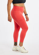Woman wearing red orange compression tights in size 12, side view