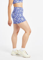 Woman wearing blue with blue flower print compression shorts in size 6, side view