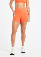 Woman wearing orange compression shorts in size 6, front view