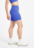 Woman wearing blue compression shorts in size 6, side view