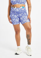 Woman wearing blue with blue floral print compression shorts in size 12, alternate front view