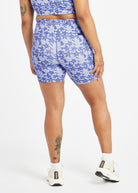 Woman wearing blue with blue floral print compression shorts in size 12, back view