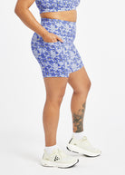 Woman wearing blue with blue floral print compression shorts in size 12, side view