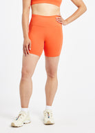Woman wearing orange compression shorts in size 6, front view