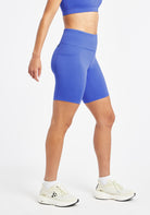 Woman wearing blue compression shorts in size 6, side view