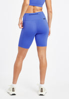 Woman wearing blue compression shorts in size 6, back view