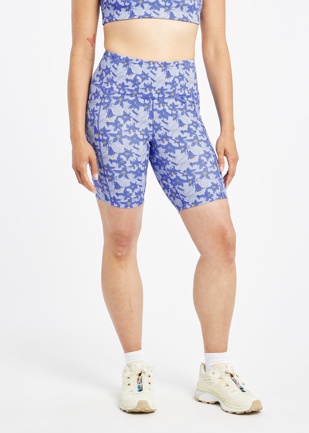 Woman wearing blue with blue floral print compression shorts in size 6, front view