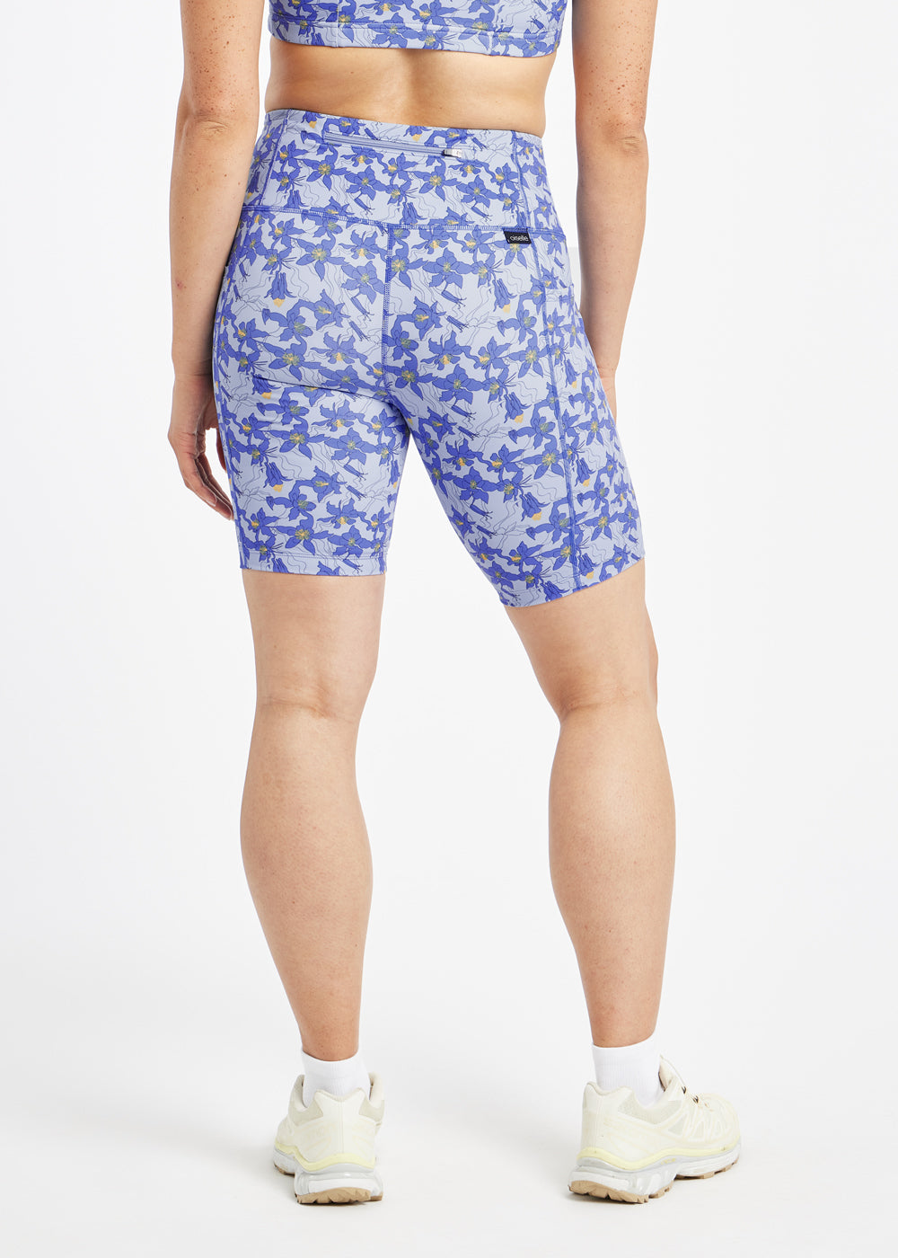 Woman wearing blue with blue floral print compression shorts in size 6, back view