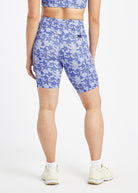Woman wearing blue with blue floral print compression shorts in size 6, back view