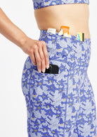 Woman wearing blue with blue floral print compression shorts, close up of side pockets