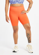 Woman wearing orange compression shorts in size 12, front view