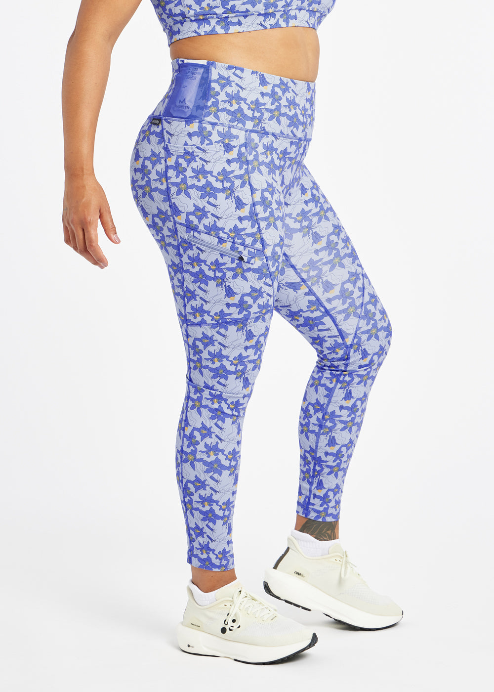 Woman wearing blue with blue flower print  running tights in size 12, side view