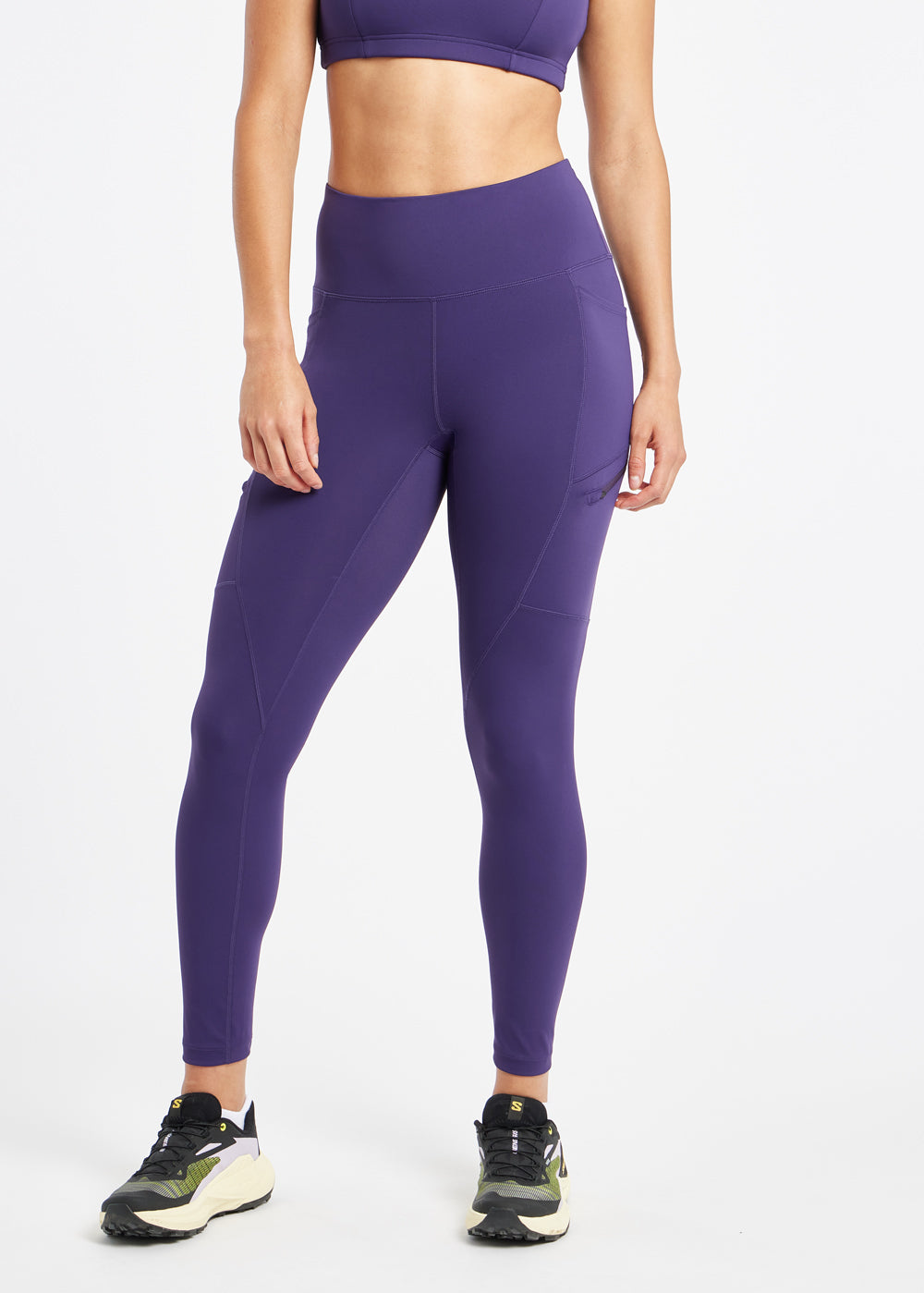 Woman wearing purple running tights in size 6, alternate front view