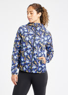 Whirlwind Running Jacket in Ink Blue Aquila Bloom Floral Print, front view with hand in pocket